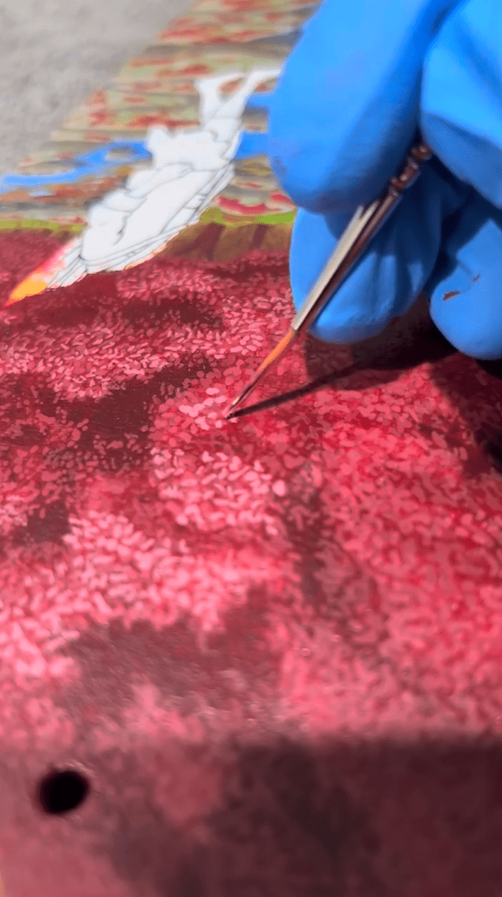 Painting red a and pink anime tree on a skateboard deck using Angelus Paints