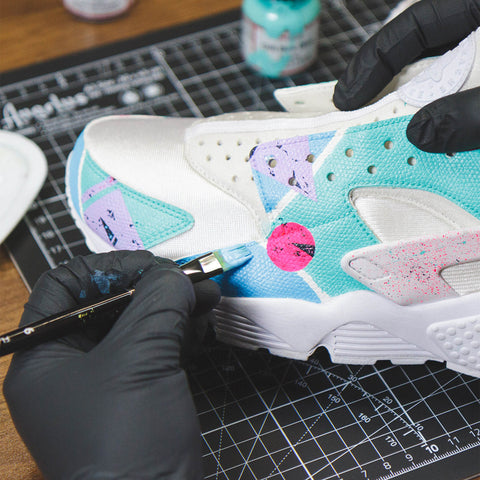 Close-up image of a shoe being painted with vibrant colors from the Angelus Starter Kit.