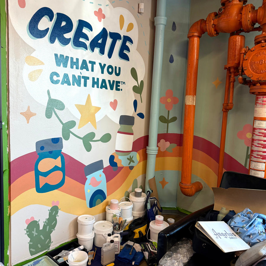 Finished Angelus Direct mural featuring cute hand-painted rainbows, stars, paint bottles, and the company founding year.