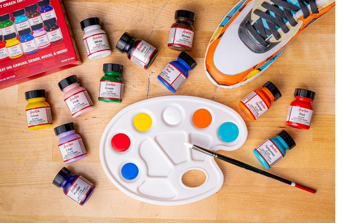 Angelus Paint bottles around a palette of primary colors ready for mixing