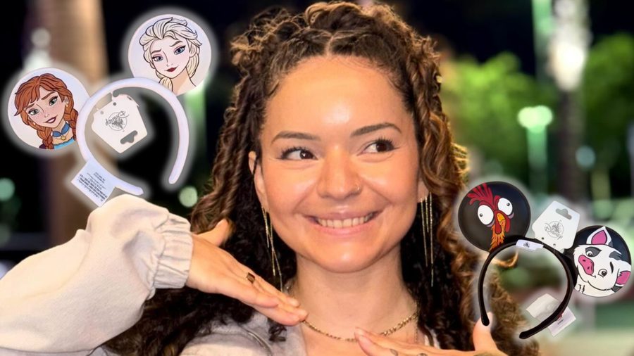 A smiling woman with long curly hair framed by two pairs of custom-painted Mickey ear headbands. The left headband is white with painted portraits of Anna and Elsa from Frozen, and the right headband is black with Heihei and Pua from Moana.