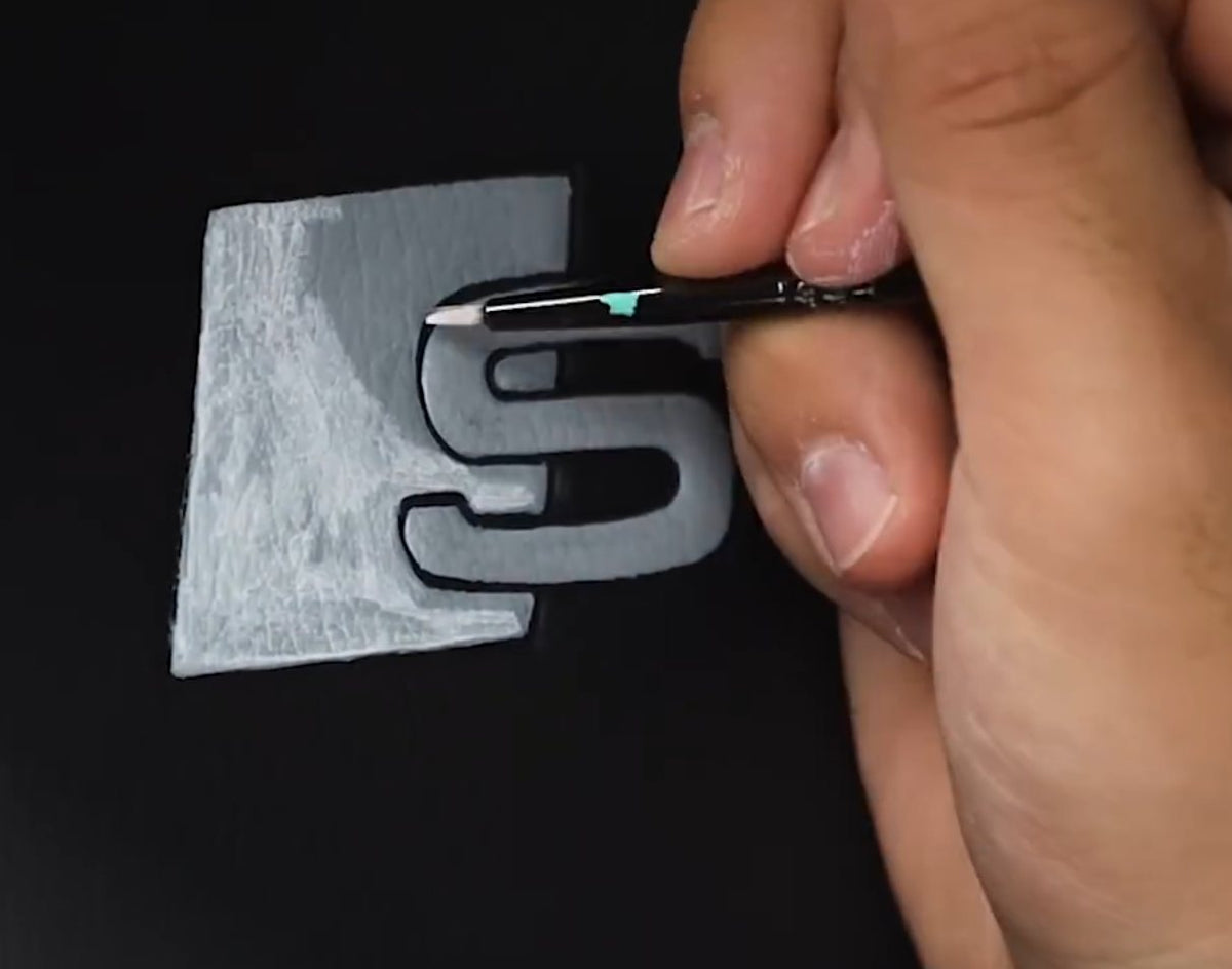 Painting an embossed logo on a leather car seat with a fine detail brush and Angelus Paint