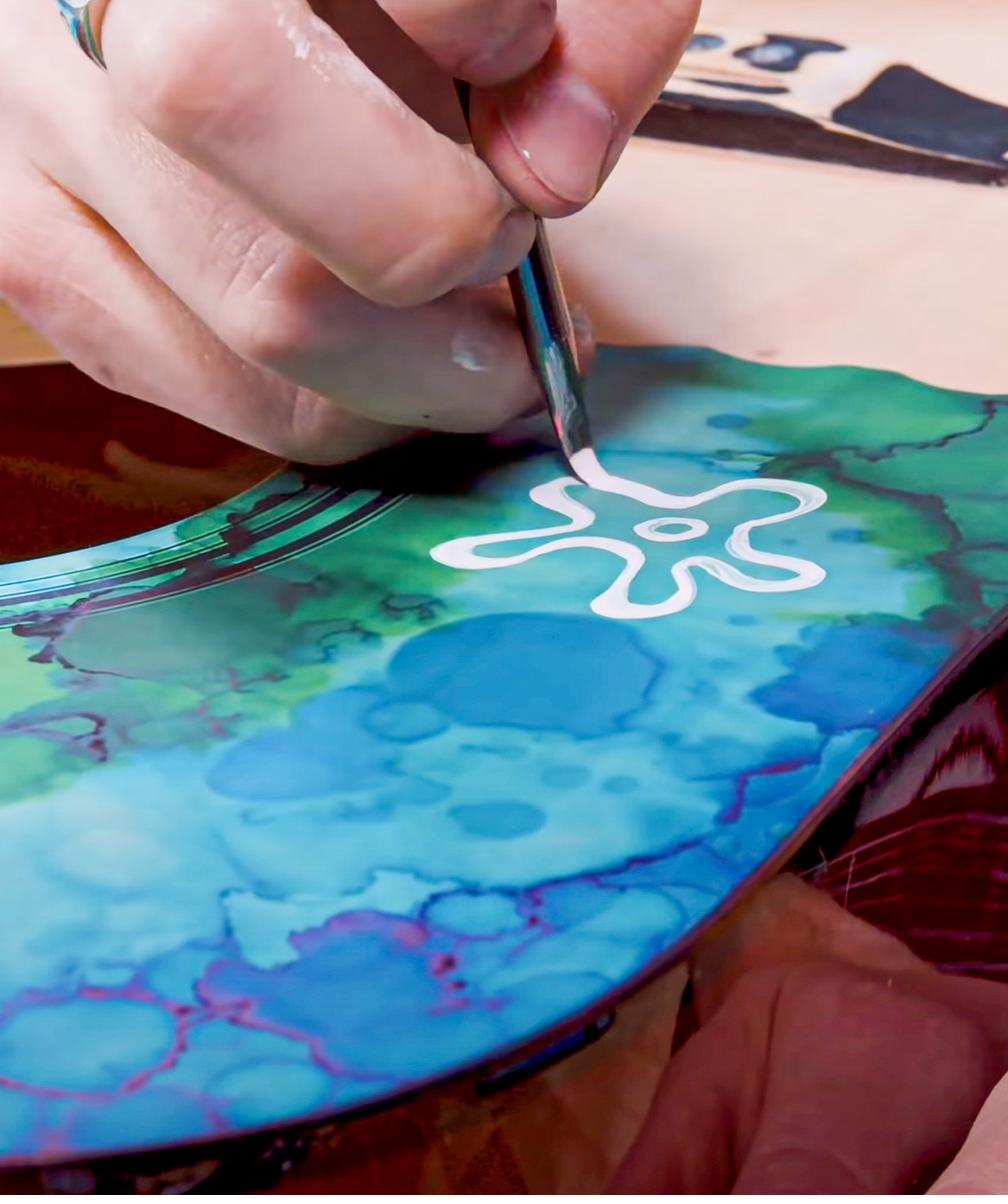 Hand painting a design on a guitar body with Angelus Paint and a fine brush