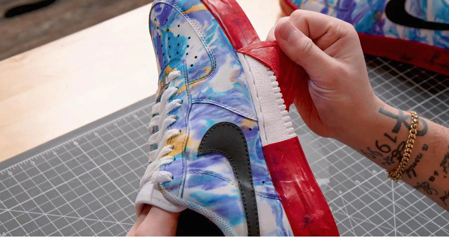 Peeling masking tape off a custom painted leather sneaker to reveal clean lines
