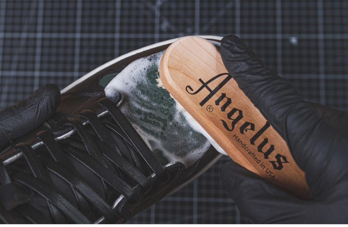 Scrubbing a black leather sneaker with the Angelus Premium Sneaker Cleaning Brush