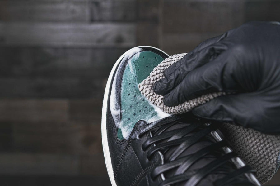 Wiping a stain off a leather sneaker with an Angelus microfiber towel