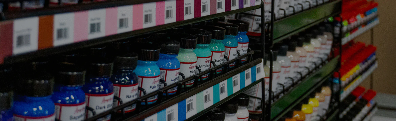 Angelus acrylic paint bottles on shelves — canvas paint collection banner