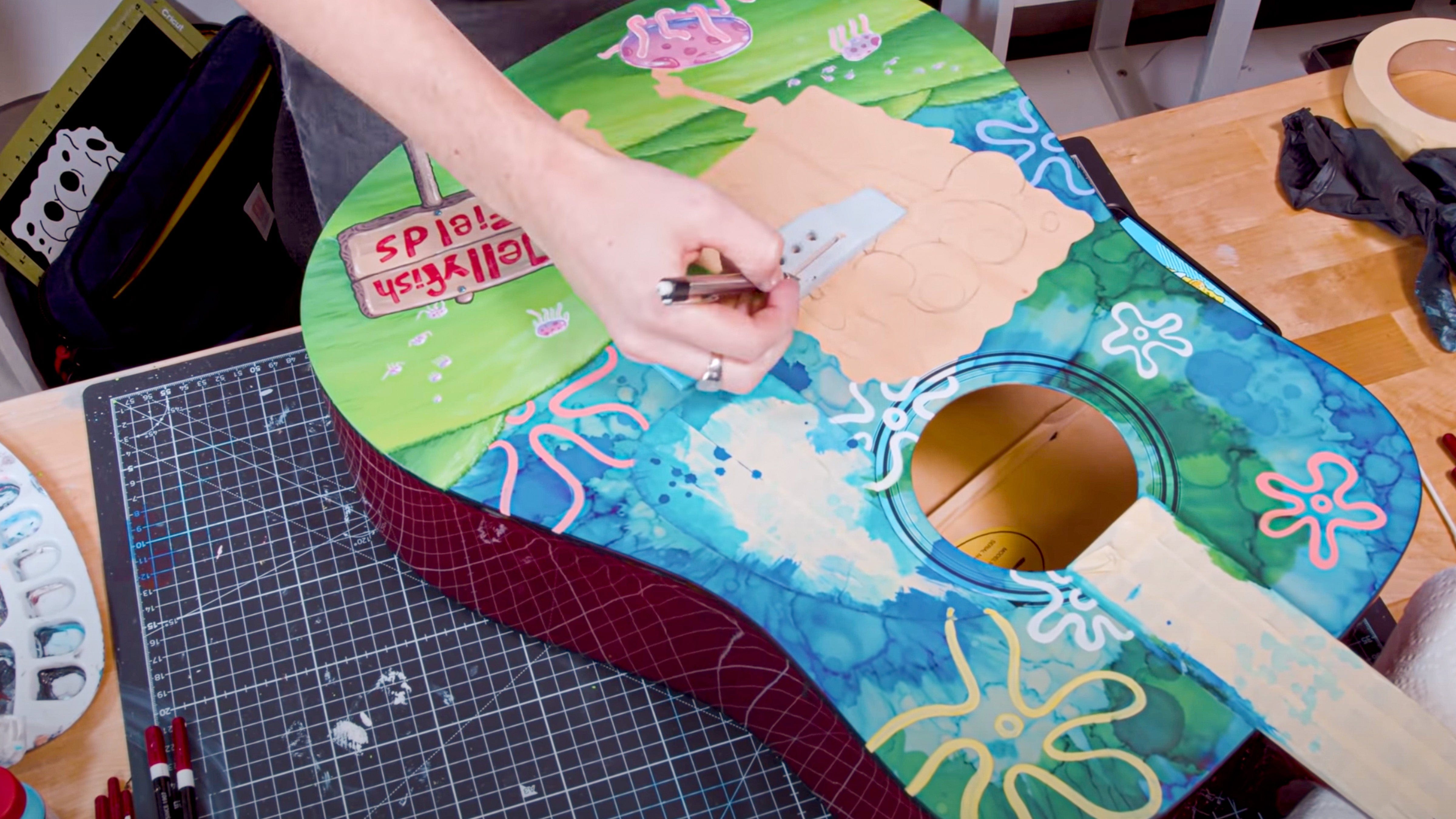 Hand-painted acoustic guitar with bright guitar paint and detailed artwork.