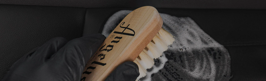 Angelus leather cleaning brush scrubbing leather with foamy cleaner.