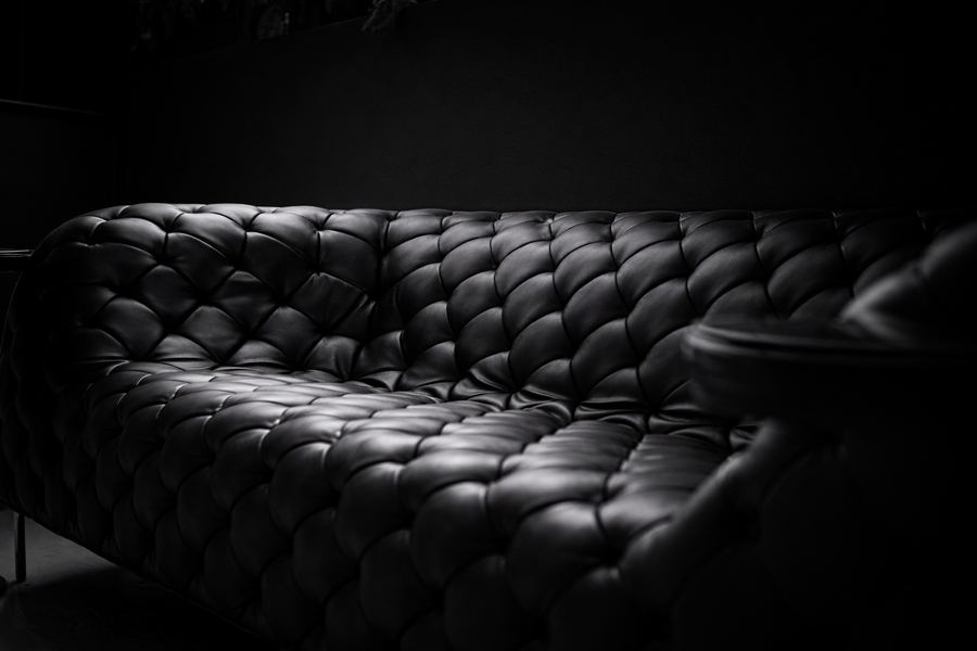 Close-up of tufted black leather couch for leather conditioner for couch