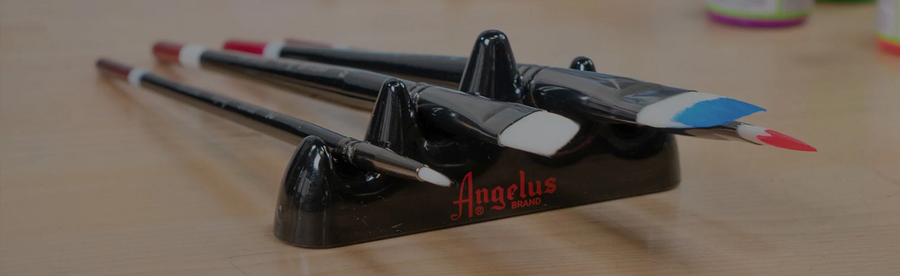 Angelus paint brushes resting on a brush holder for paint by number projects.
