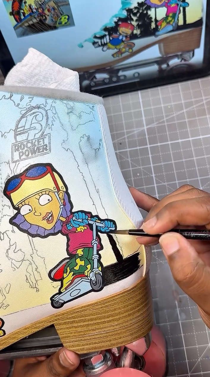 Painting black palm tree silhouettes on a custom roller skate mural