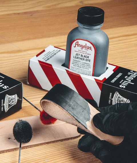 Angelus Jet Black Leather Dye being applied to a leather strip