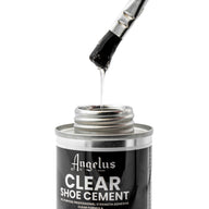 A brush coated with Angelus Direct’s Angelus Clear Shoe Cement is lifted from an open tin. The thick, stringy adhesive is ideal for re-gluing shoe soles or as an all-purpose glue.